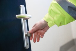 Building manager inspecting a fire door to ensure compliance with safety regulations.