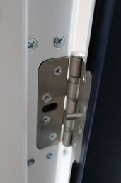 Inspecting the hinges of a fire door to ensure proper functionality and safety.