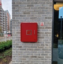 A Premises Information Box by Gerda Security installed on the exterior wall of a modern building.